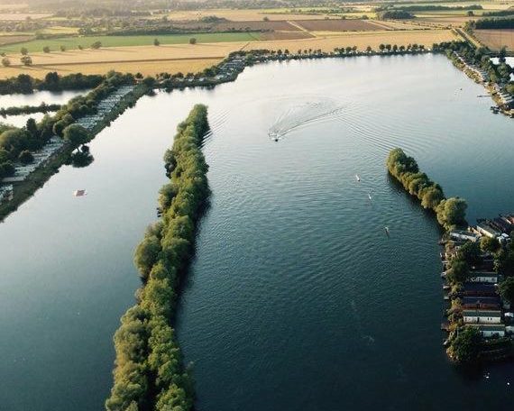 Aerial view of lakes surrounded by green trees and fields.